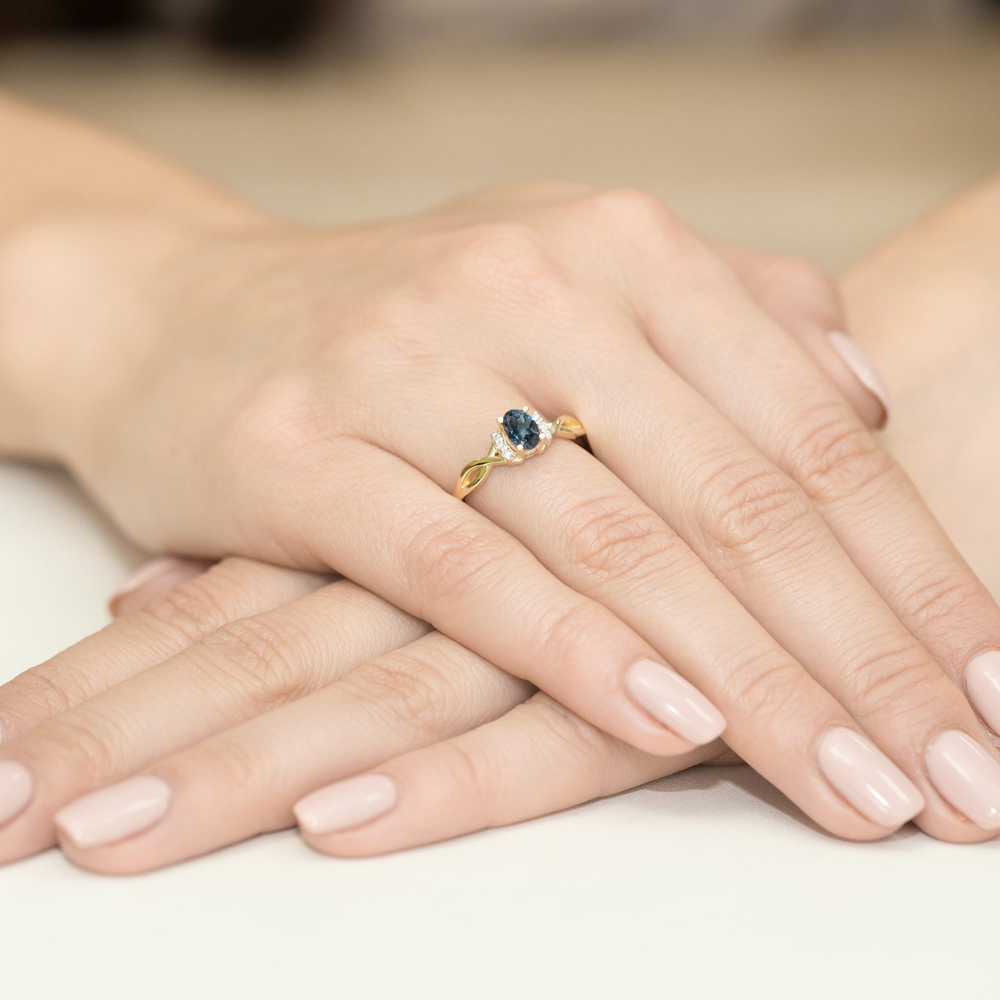 Złoty pierścionek z Topazem London Blue i brylantami ze skręconą szyną