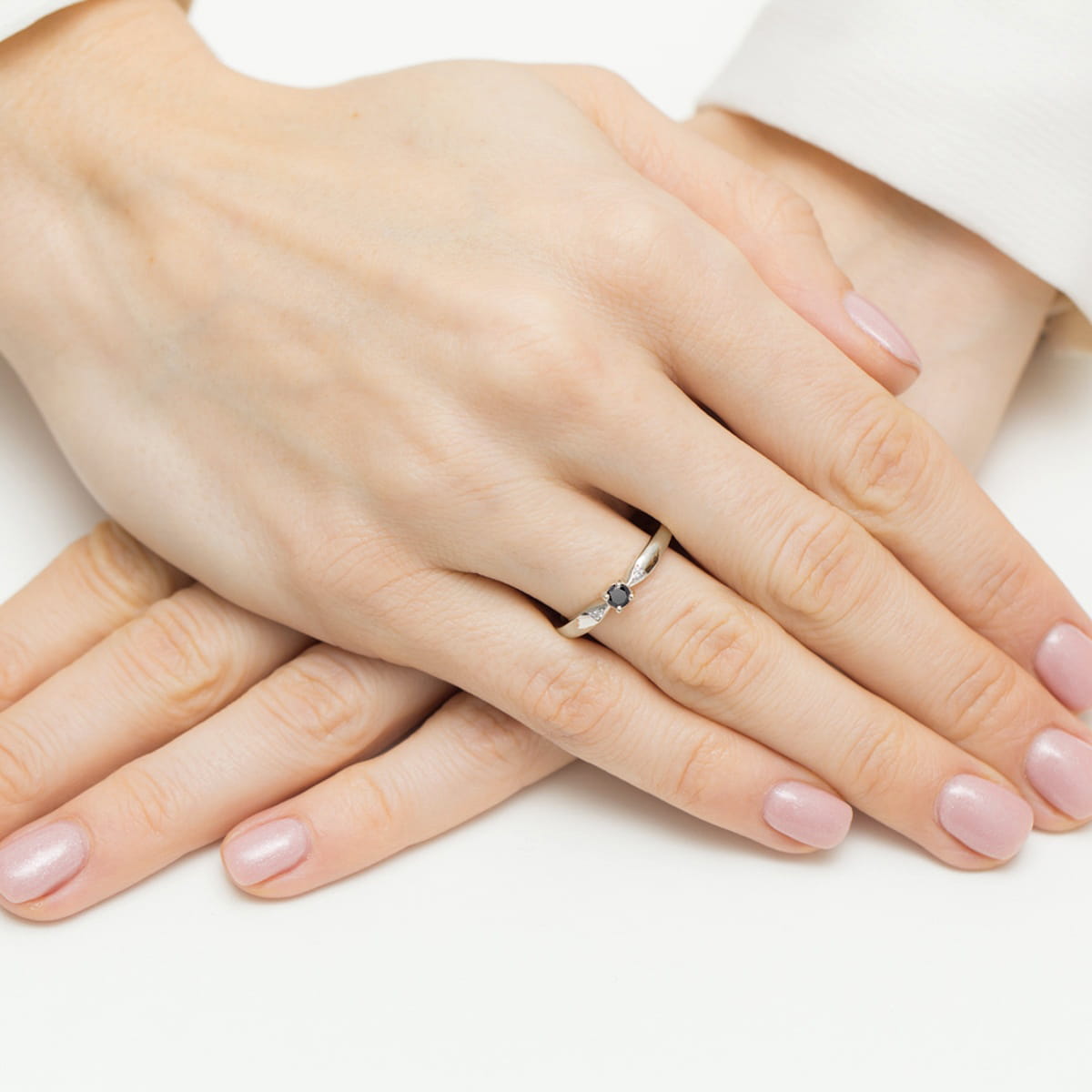 Pierścionek z białego złota z czarnym brylantem i dwoma brylancikami na zwężanej szynie